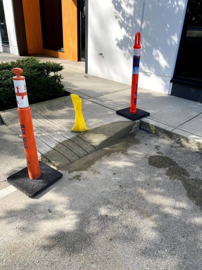 A small concrete ramp on the sidewalk.